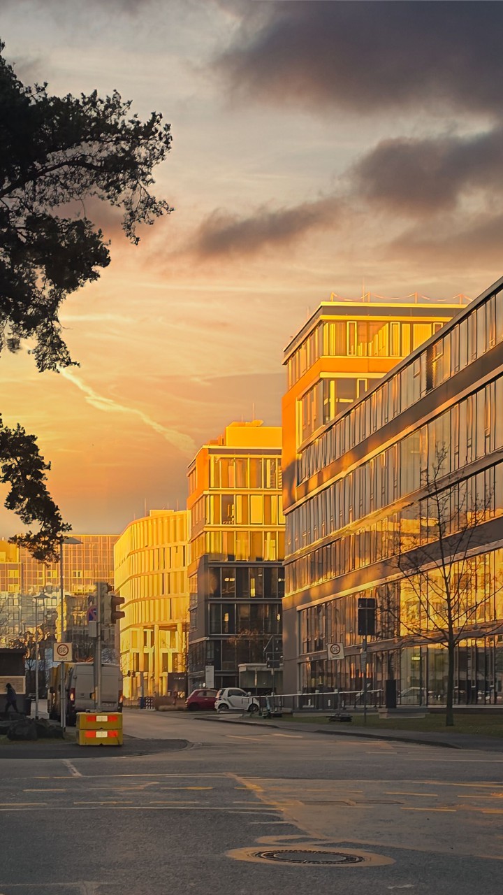 Das Foto zeigt Bürogebäude in goldener Farbe bei Abendlicht mit goldenem Himmel und dunklen Wolken. Aufgenommen im Januar 2025 in Darmstadt im Industriegebiet.